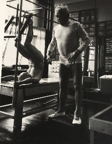 Archival black-and-white photograph of Joseph Pilates working on apparatus